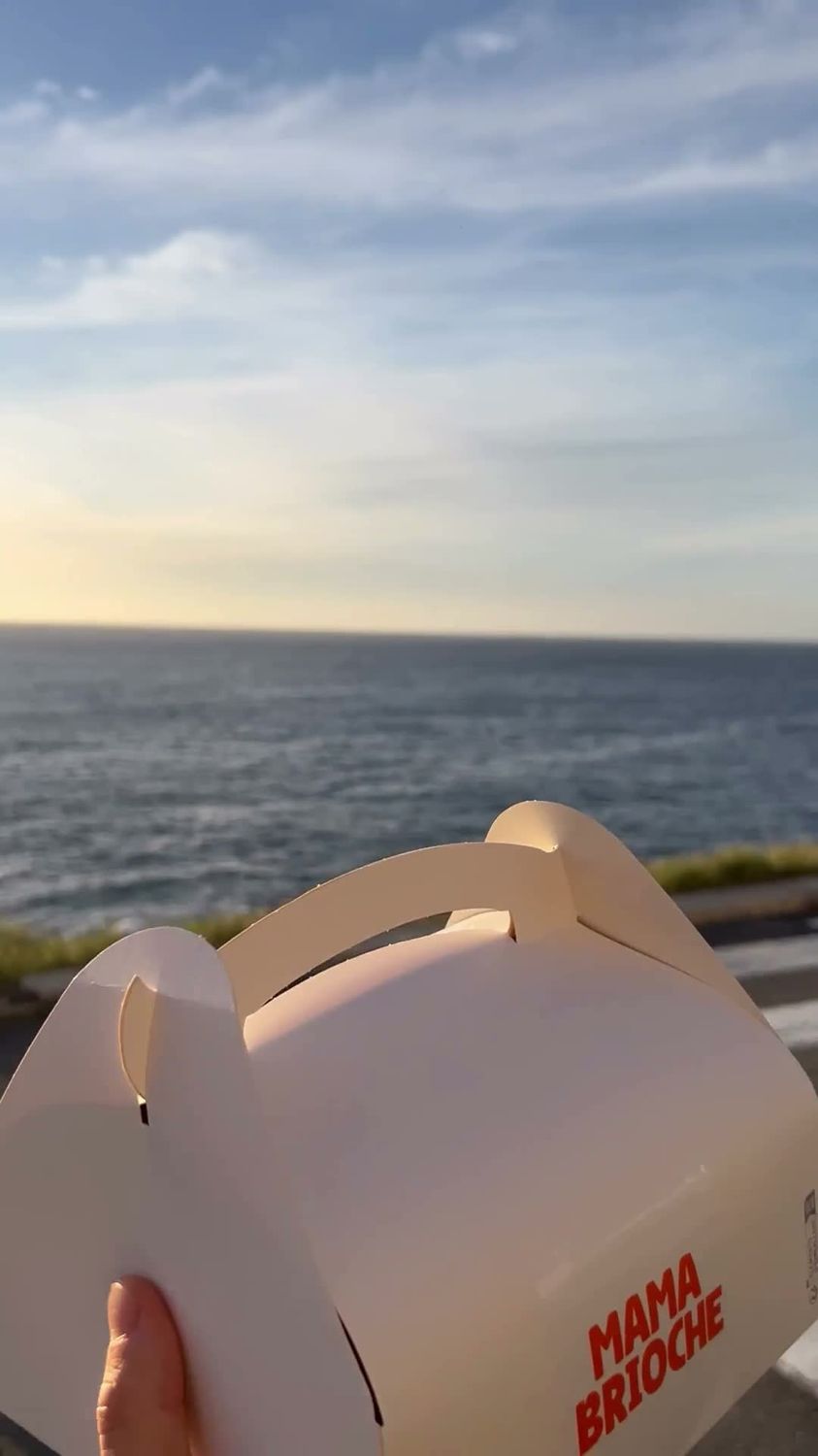 Box à emporter Pastagars tenue à la main face à la mer au coucher du soleil, à Marseille